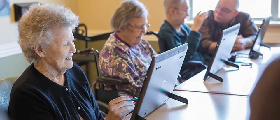 Three women residents using iPads during a computer class