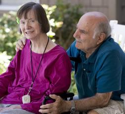 Resident couple with husband's arms around his wife.