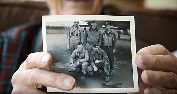 A resident veteran holding a photo of him and four of his air-force buddies.