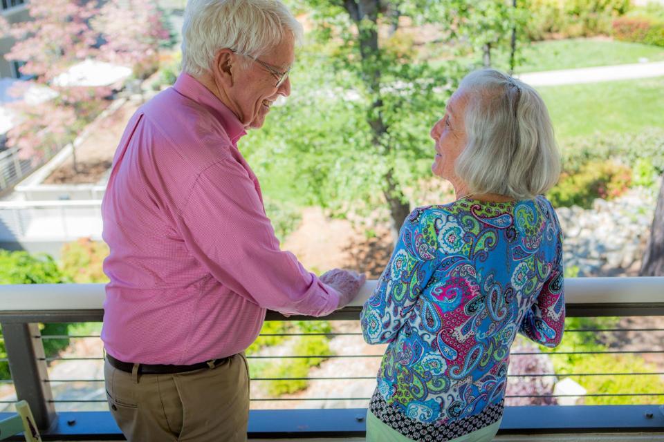 Couple on their balcony smiling at each other