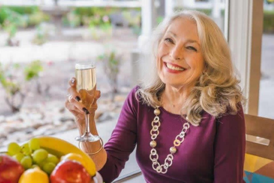 Woman  holding a glass of champagne, smiling.