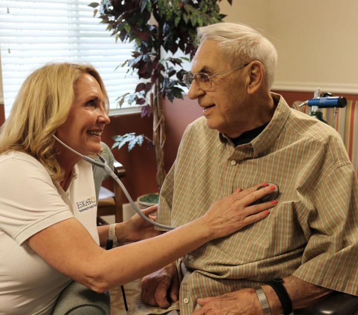 A nurse with stethoscope listening to a residents chest