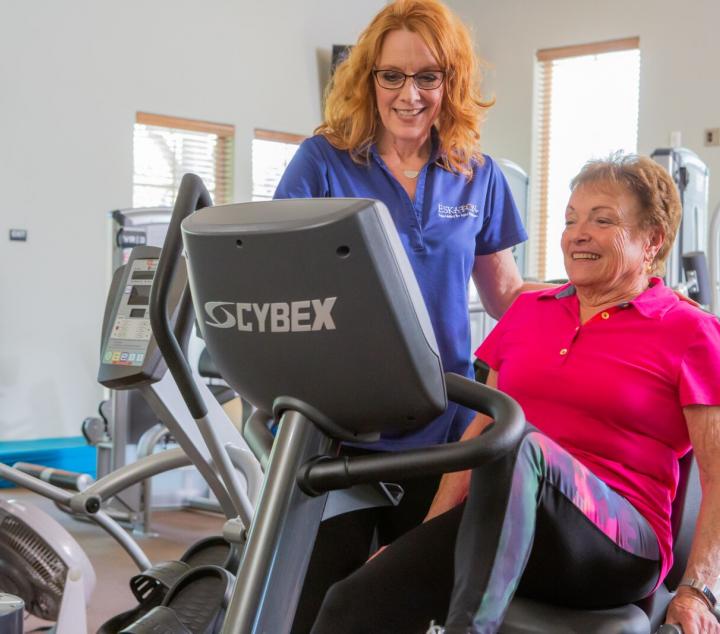 Staff member with resident on a stationary bike.