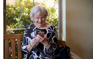 Woman sitting a bench, face-timing with her mobile phone