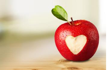 A red apple with a heart cut out of the center