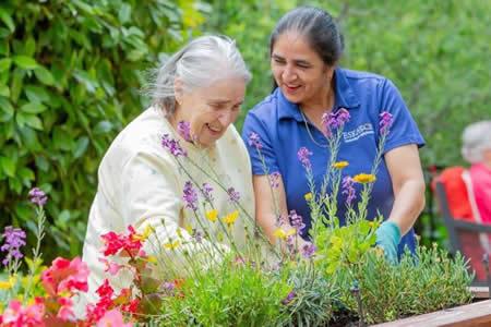 Resident and staff gardening together