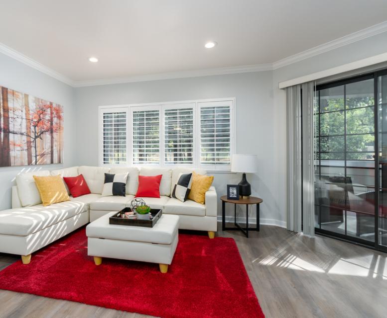 Apartment living with red area rug and a view of the patio