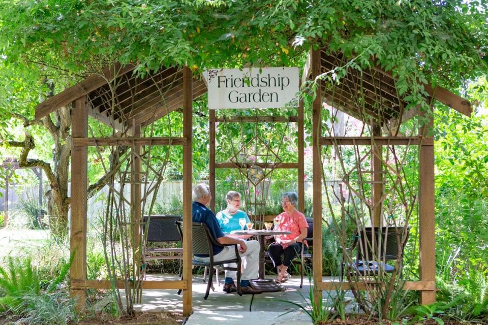 three residents sitting in the Friendship Garden's gazebo 