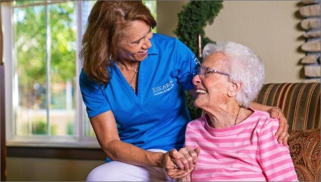 Staff smiling with her arms around a woman resident