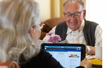 an older couple looking at their iPad