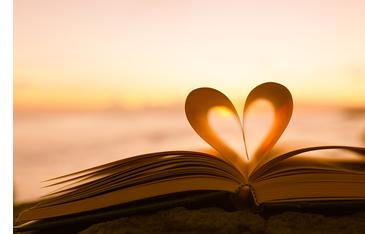 Open book with middle two pages folded into the middle to make the shape of a heart