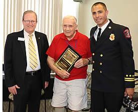 A resident being honored by the City of  Pleasanton's Major and Pleasanton Fire Battalion Chief.