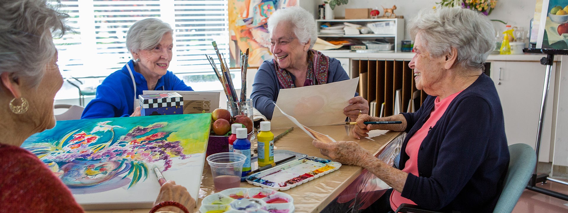Four women creating painted artwork