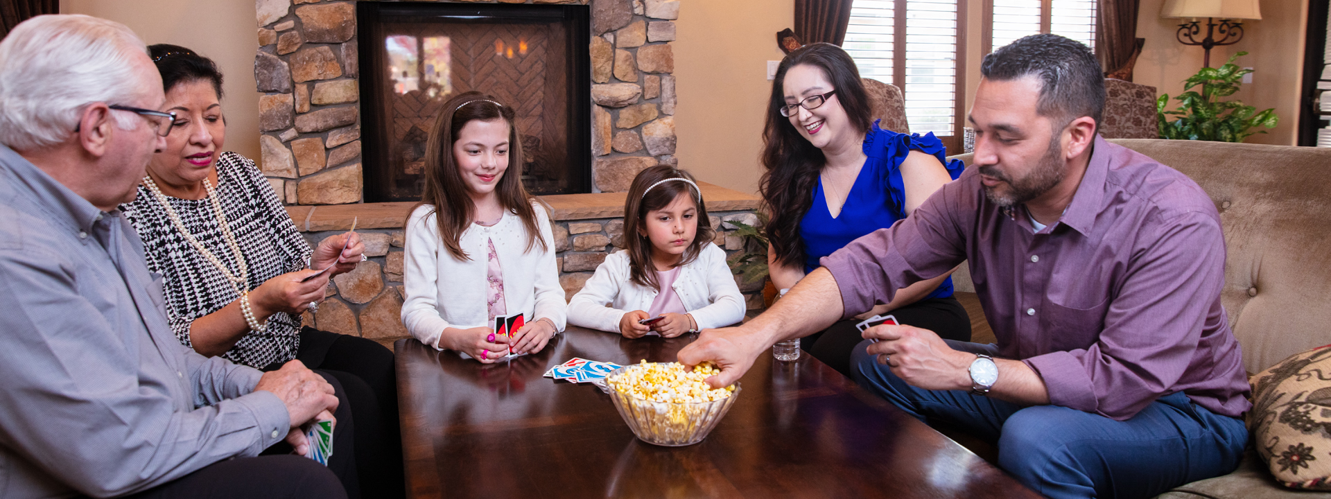 Family playing cards and eating popcorn