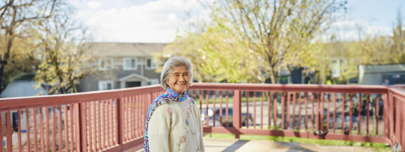 Woman smiling on her outside deck.